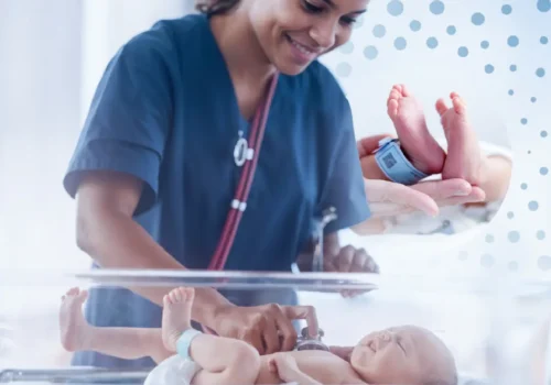 Nurse applying RFID tag to newborn in hospital ward